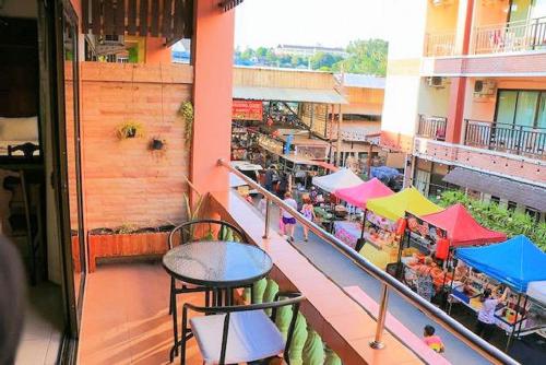 un balcone di un edificio con tavoli e ombrelloni di Sue@Cozy Guesthouse a Kata Beach