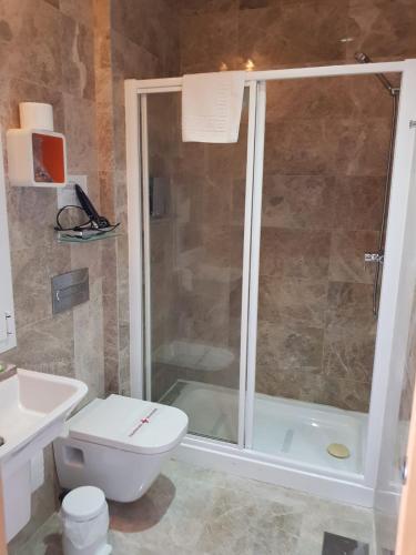 a bathroom with a shower and a toilet and a sink at Hotel Senderos in Agua Amarga