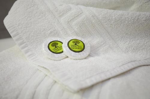 twee groene en witte stickers op een witte deken bij Zorbas Apartments in Volissos
