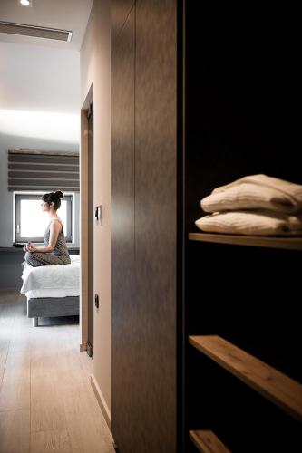 a woman sitting on a bed in a bedroom at Ciel Collection Suites in Chania Town