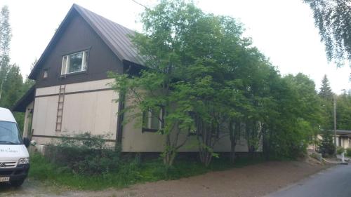 uma casa com uma árvore em frente em Hostel Varkaus em Varkaus