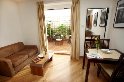 a living room with a couch and a table at Presidential Apartments Kensington in London