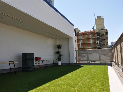 a balcony with green grass on a building at Guest House Matsu in Osaka