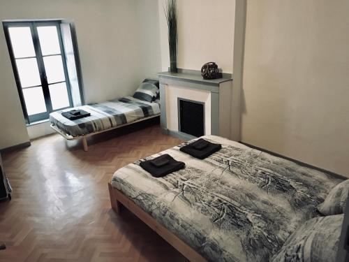 - un salon avec deux lits et une cheminée dans l'établissement APPARTEMENT PROCHE CITÈ MEDIEVALE 4 pers, à Carcassonne