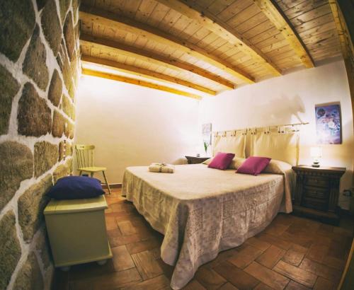 una camera con letto e parete in pietra di La casetta a Terrasini
