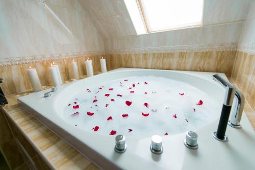 una vasca da bagno con cuori rossi sopra di AllureInn Hotel and Spa a Černivci
