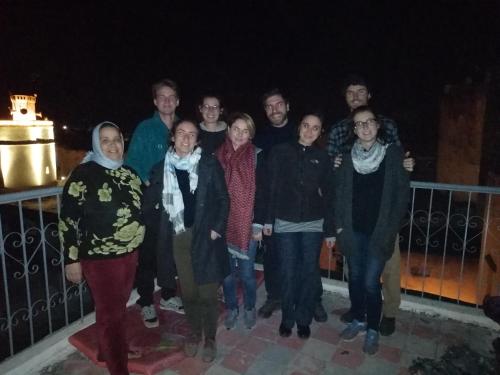 eine Gruppe von Menschen steht nachts auf einem Balkon in der Unterkunft Dar Elkorchi in Fès
