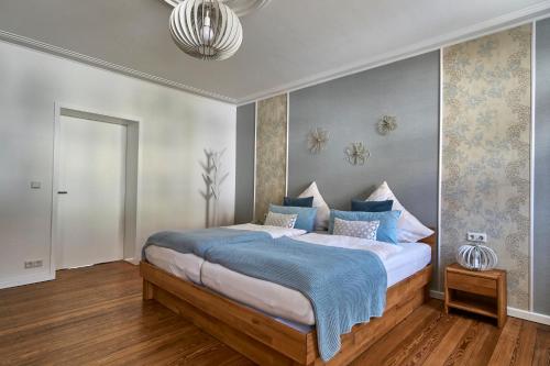 a bedroom with a large bed with a blue blanket at Ferienwohnung Atrium in Niederlinxweiler