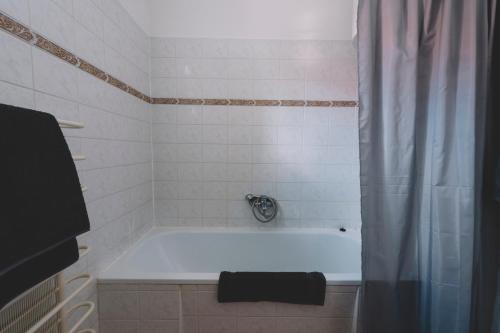 a bathroom with a bath tub with a shower curtain at Noresa Dekor és Panzió in Szálka