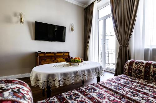 una stanza con un tavolo con una ciotola di frutta sopra di Nostalgia Apartment a Klaipėda