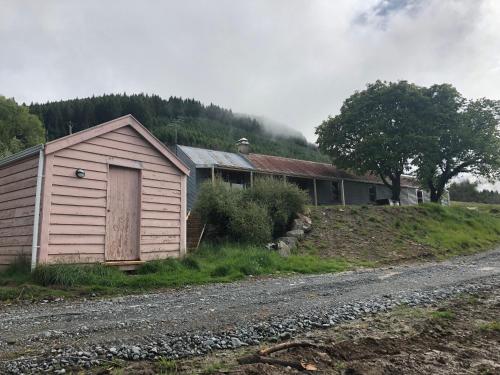 a small building on the side of a dirt road at Mount Cook Station Shearers Quarters Lodge in Lake Tekapo