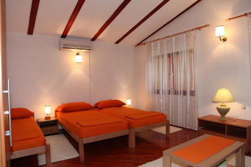 1 dormitorio con cama de color naranja y ventana en Guest House Goa Mostar, en Mostar