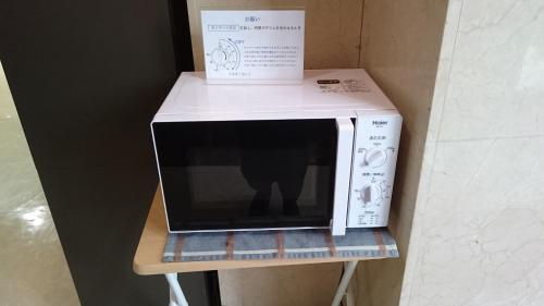 a white microwave with a box on top of it at Hotel New Century Sakaide in Sakaide