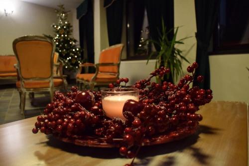 a candle and a bunch of fruit on a table at Vila Seva in Vatra Dornei