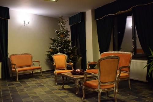 a christmas tree in a room with chairs and a table at Vila Seva in Vatra Dornei