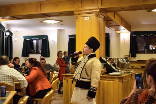 a man singing into a microphone in a restaurant at Vila Seva in Vatra Dornei