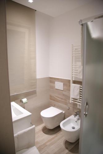 La salle de bains est pourvue de toilettes blanches et d'un lavabo. dans l'établissement B&b Antigua, à Altamura