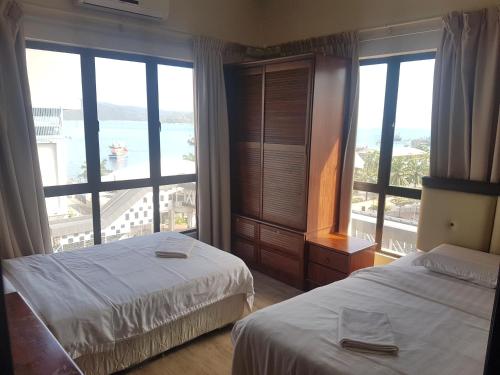 a hotel room with two beds and a large window at Peter Holiday Home @ Marina Court Condo in Kota Kinabalu