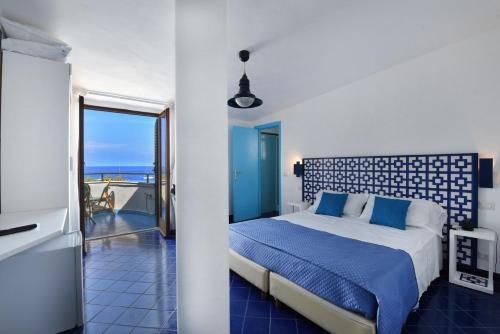 1 dormitorio con cama y vistas al océano en Hotel Baia Di Puolo, en Massa Lubrense