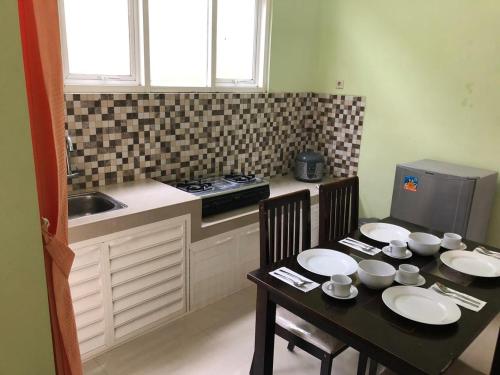 a kitchen with a table and two chairs and a sink at Villa Safira in Batu
