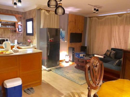 a kitchen and living room with a refrigerator and a couch at Chalet in Bluebay Asia Resort Ain Sokhna in Ain Sokhna