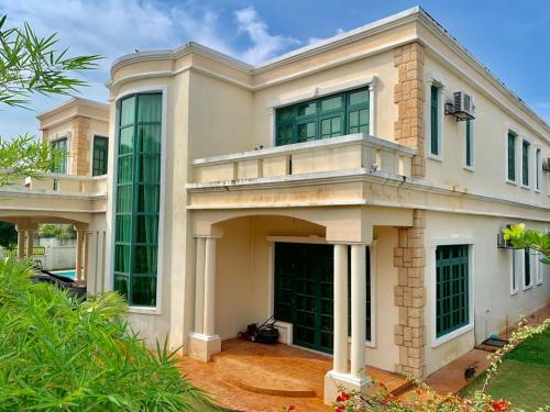 a large white house with large windows at VILLA SHAMIR in Sepang