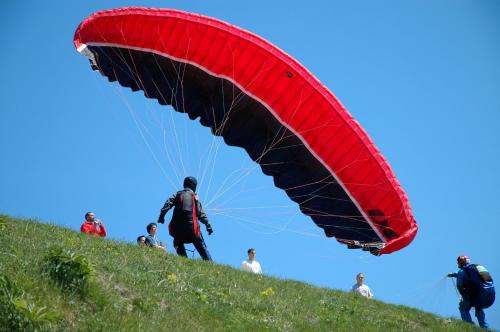 a person flying a red parachute on a hill at Apartments Slap in Slappe dʼIdria