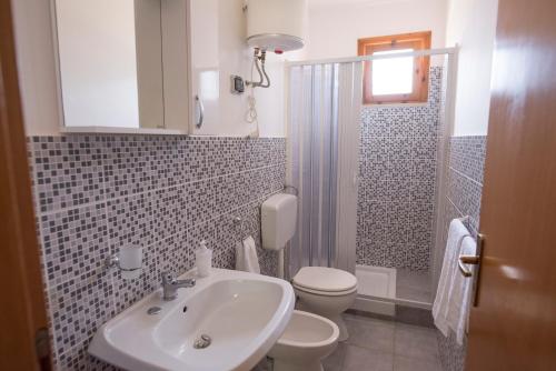 ein Bad mit einem Waschbecken, einem WC und einer Dusche in der Unterkunft Case Vacanza Renella 3 beds: Balcony, wifi, self-catering, 200mt from the sea in Sciacca