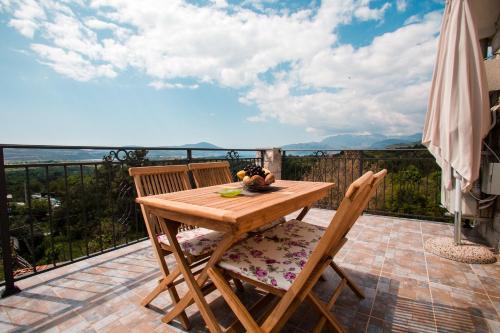 einen Holztisch und Stühle auf dem Balkon in der Unterkunft Sunny Nest Apartments in Kotor