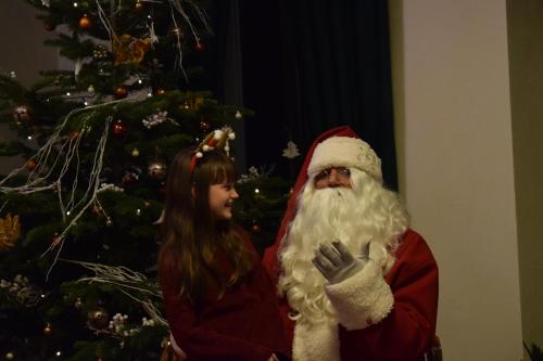 a little girl standing next to a christmas tree at Vila Seva in Vatra Dornei