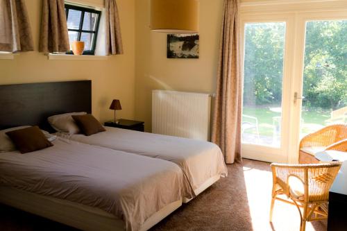 1 dormitorio con cama y ventana grande en Bed and Breakfast De Grote Byvanck en Westervoort