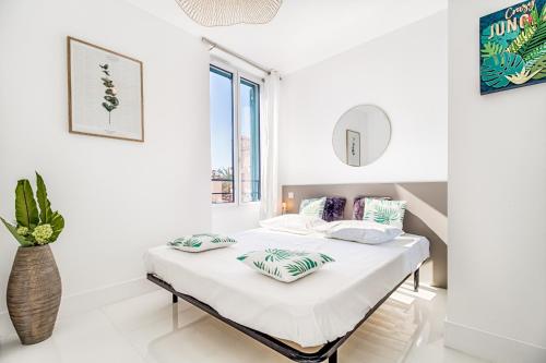 a white bedroom with a bed with pillows on it at NEW ! SEA VIEW Design + Balcony 203 in Villefranche-sur-Mer