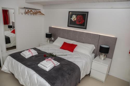 1 dormitorio con 1 cama blanca grande con almohadas rojas en LA CIVITA B&B, en Gravina in Puglia