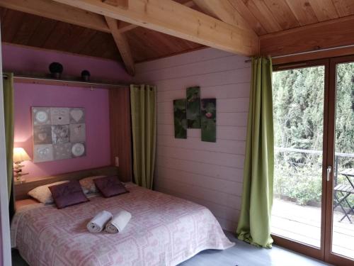 une chambre avec un lit et une grande fenêtre dans l'établissement Le Chalet Zen, à Lagrasse