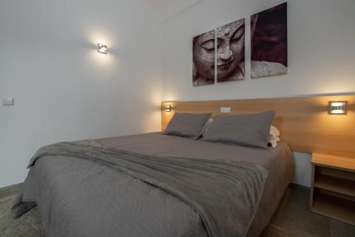 a bedroom with a bed with two pictures on the wall at Villa Welwitshia in Carvoeiro