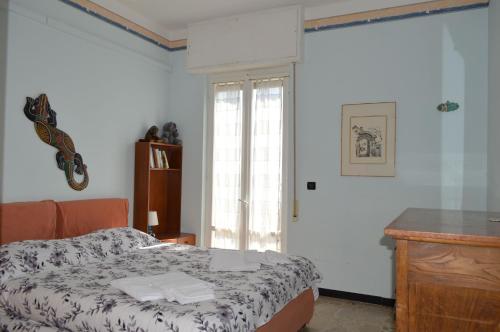 a bedroom with a bed and a desk and a window at Appartamento "Abbracciando il Mare" in Laigueglia