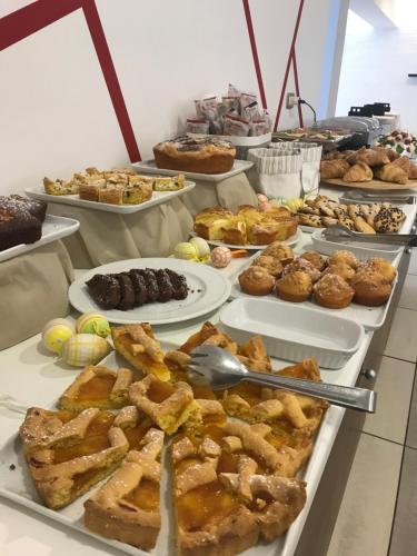 a buffet filled with different types of pastries and pies at Hotel Royal in San Benedetto del Tronto