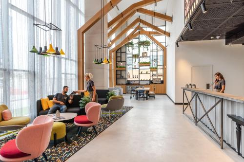 a lobby with people sitting on couches and tables at Studio One Hotel in Dubai