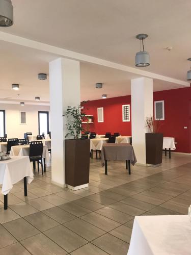 聖貝內代托德爾特龍托的住宿－Hotel Royal，一间带桌椅和红色墙壁的餐厅
