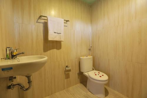 a bathroom with a white toilet and a sink at Yoki's Bungalow in Kuta Lombok