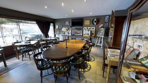 a dining room with a large wooden table and chairs at Hotel City Bell in La Plata