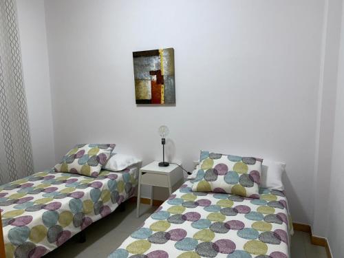 Un dormitorio con dos camas y un cuadro en la pared. en apartamento Augusto, en Los Llanos de Aridane