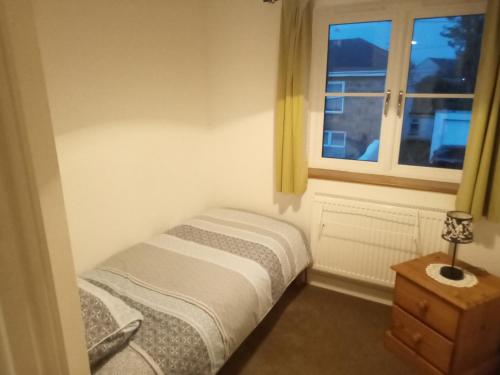 a small bedroom with a bed and a window at Sammy's place in Hayle