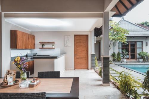 a kitchen and dining area of a house with a pool at Dura Villas Bali at Kerobokan in Kerobokan
