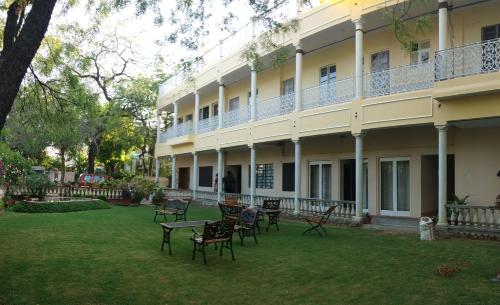 a building with chairs and tables in the yard at Hotel Jai Niwas in Jaipur