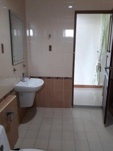 a bathroom with a sink and a toilet and a mirror at Uncle House Krabi in Krabi town