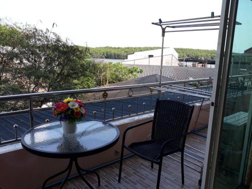 a balcony with a table and two chairs and a vase of flowers at Uncle House Krabi in Krabi town