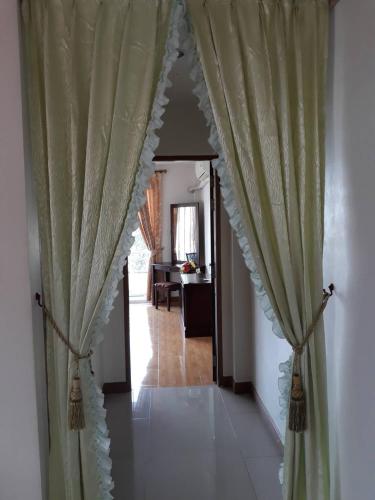 a hallway with green curtains and a hallway with a table at Uncle House Krabi in Krabi town
