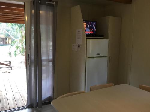 Camping du Soleil في Appietto: مطبخ مع طاولة وثلاجة ونافذة