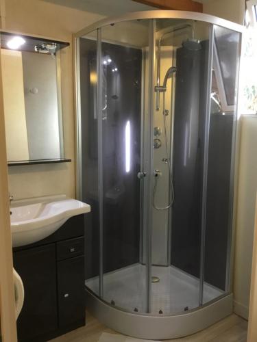 a bathroom with a shower and a sink at Camping du Soleil in Appietto